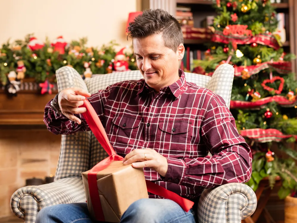 Mann öffnet ein Geschenk